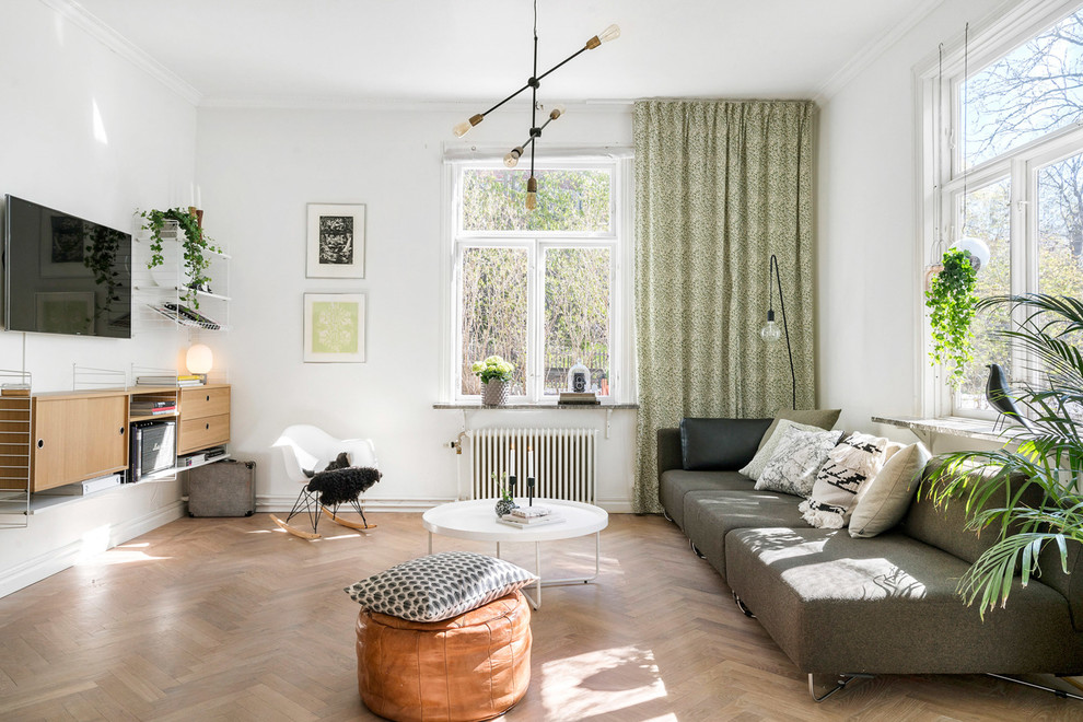 Großes, Abgetrenntes Nordisches Wohnzimmer ohne Kamin mit weißer Wandfarbe, braunem Holzboden, TV-Wand und braunem Boden in Kopenhagen
