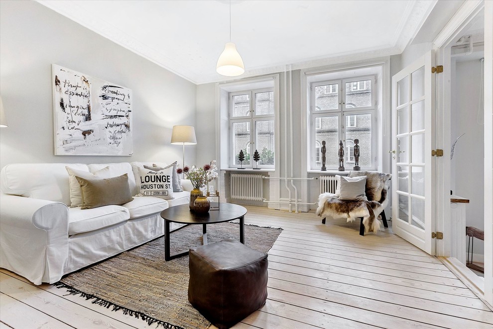Skandinavisches Wohnzimmer mit grauer Wandfarbe, hellem Holzboden und beigem Boden in Kopenhagen