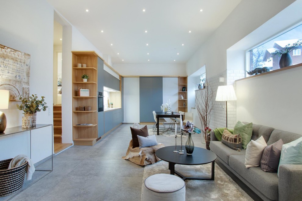 Cette image montre un salon design de taille moyenne et ouvert avec un mur blanc, sol en béton ciré et un sol gris.