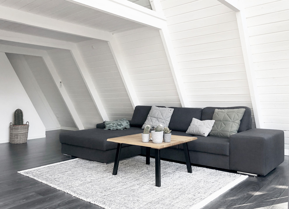 Diseño de salón abierto escandinavo con paredes blancas, suelo de madera oscura y suelo gris