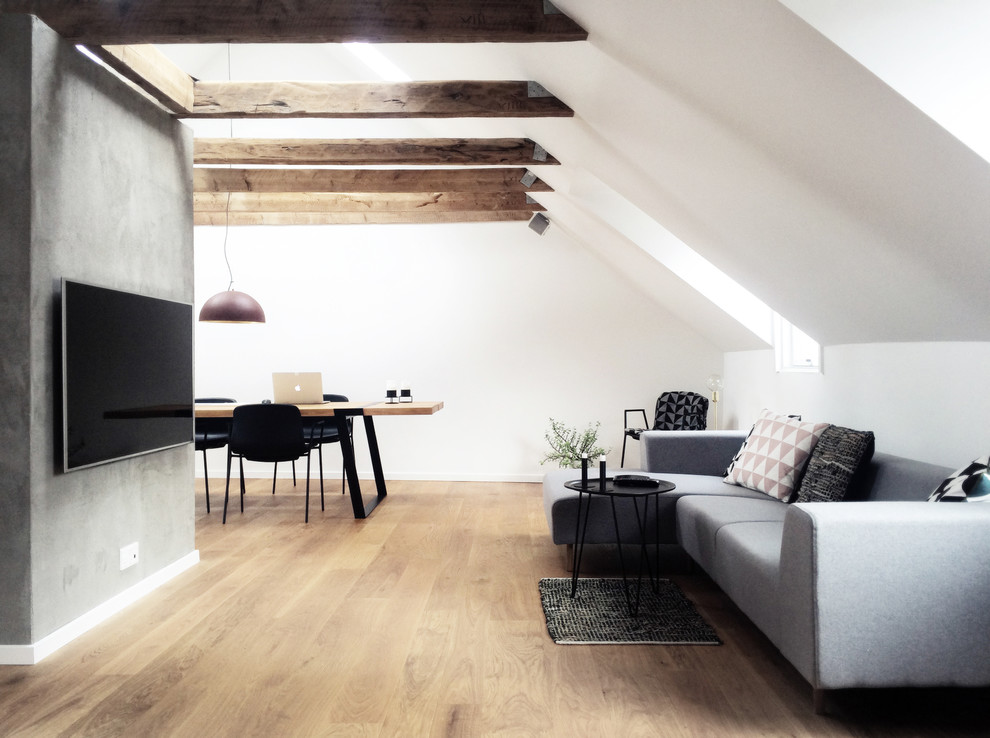 Ejemplo de salón abierto escandinavo con paredes blancas, suelo de madera en tonos medios y televisor colgado en la pared