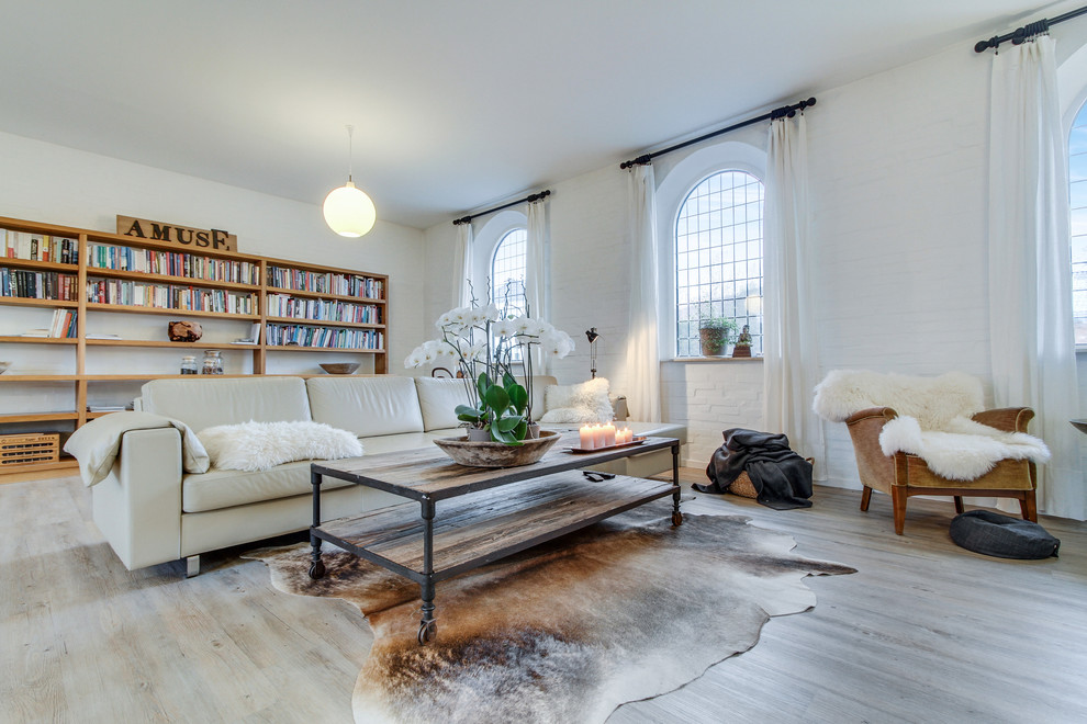 Idée de décoration pour un grand salon nordique ouvert avec une bibliothèque ou un coin lecture, un mur blanc, parquet clair, aucune cheminée et aucun téléviseur.