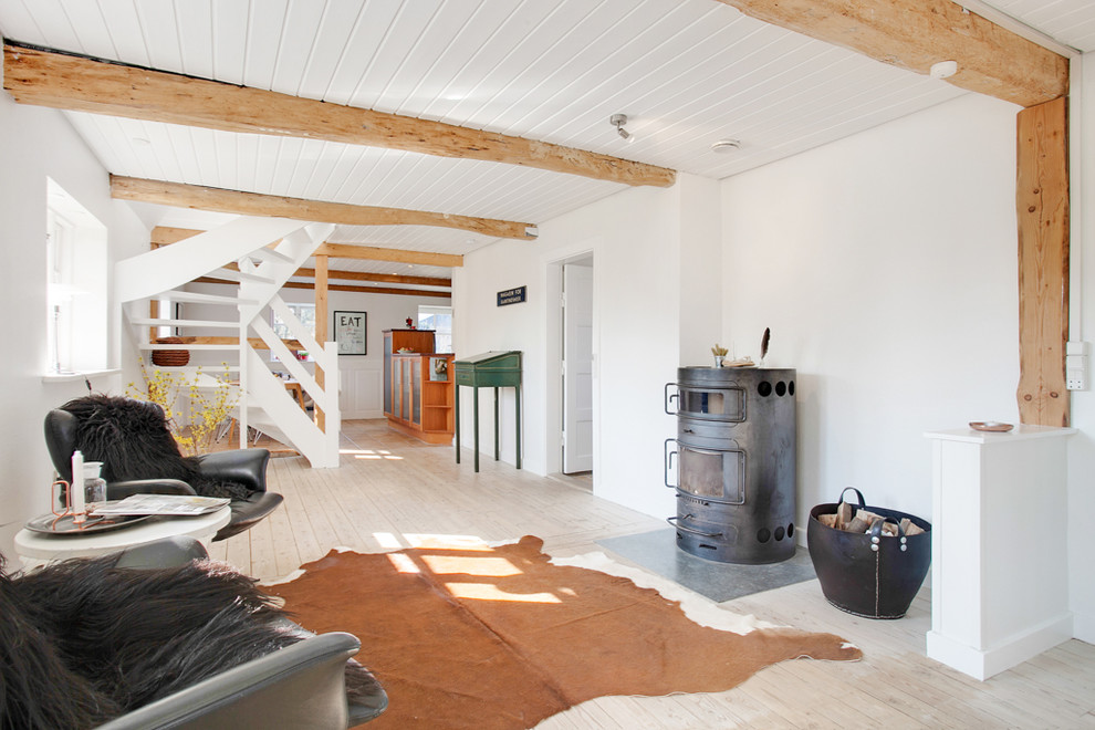 Идея дизайна: большая открытая, парадная гостиная комната в скандинавском стиле с белыми стенами, светлым паркетным полом, печью-буржуйкой и фасадом камина из металла без телевизора