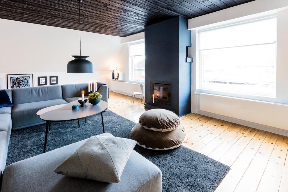 Fernseherloses Skandinavisches Wohnzimmer mit weißer Wandfarbe, braunem Holzboden, Gaskamin und Kaminumrandung aus Metall in Aarhus