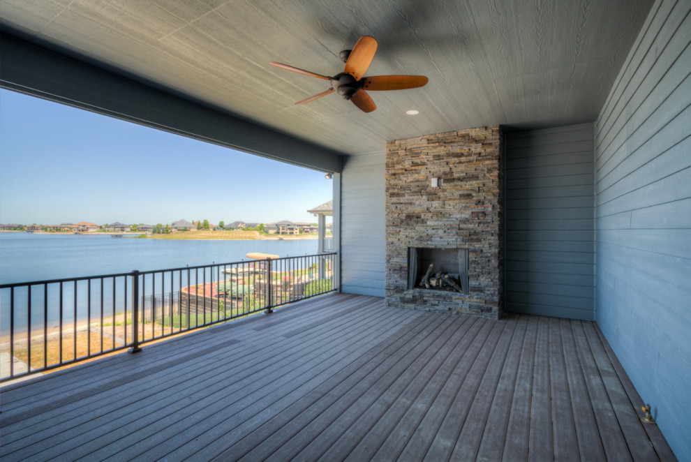 Inspiration for a modern deck remodel in Omaha with a fireplace and a roof extension