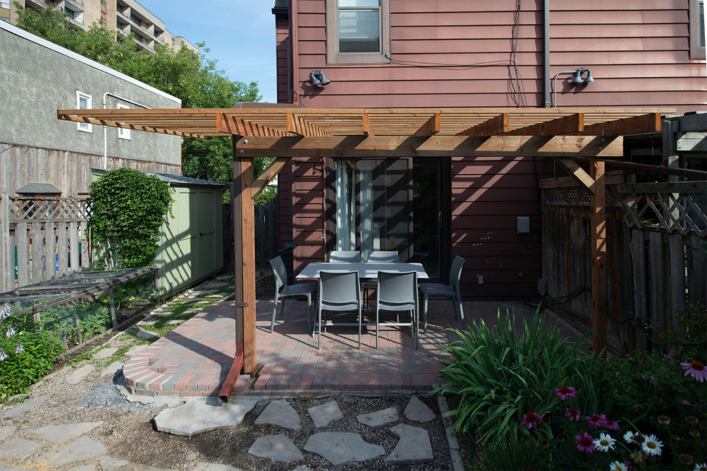 Immagine di una grande privacy sulla terrazza moderna dietro casa con una pergola