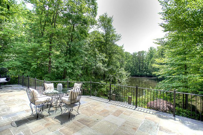 This is an example of an expansive mediterranean back terrace in Atlanta with a water feature and no cover.