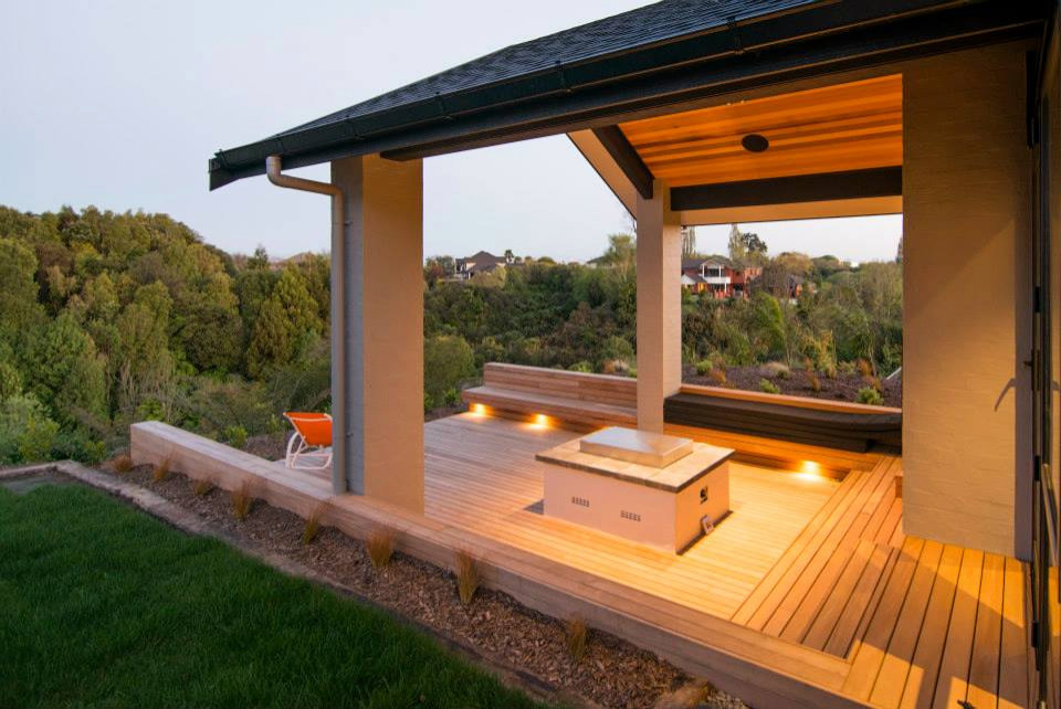 Esempio di una grande terrazza minimalista dietro casa con un caminetto e un tetto a sbalzo