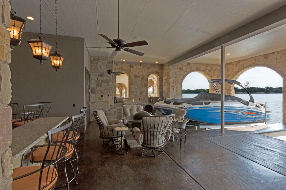 Example of a large transitional backyard dock design in Austin with a roof extension
