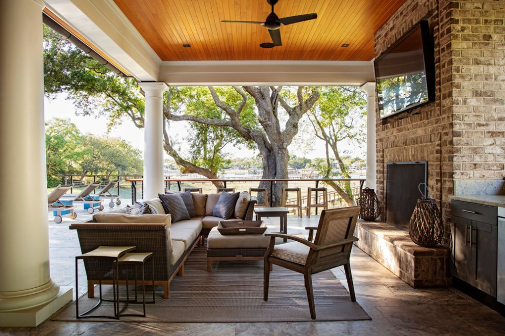 Large beach style back terrace in Charleston with an outdoor kitchen and a roof extension.