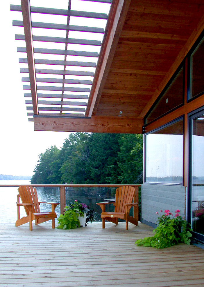 Cette image montre une terrasse avec des plantes en pots chalet de taille moyenne avec une extension de toiture.