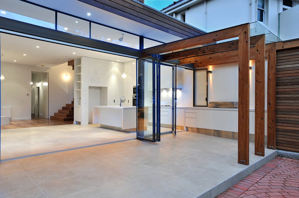This is an example of a medium sized contemporary back terrace in Melbourne with an outdoor kitchen and a pergola.