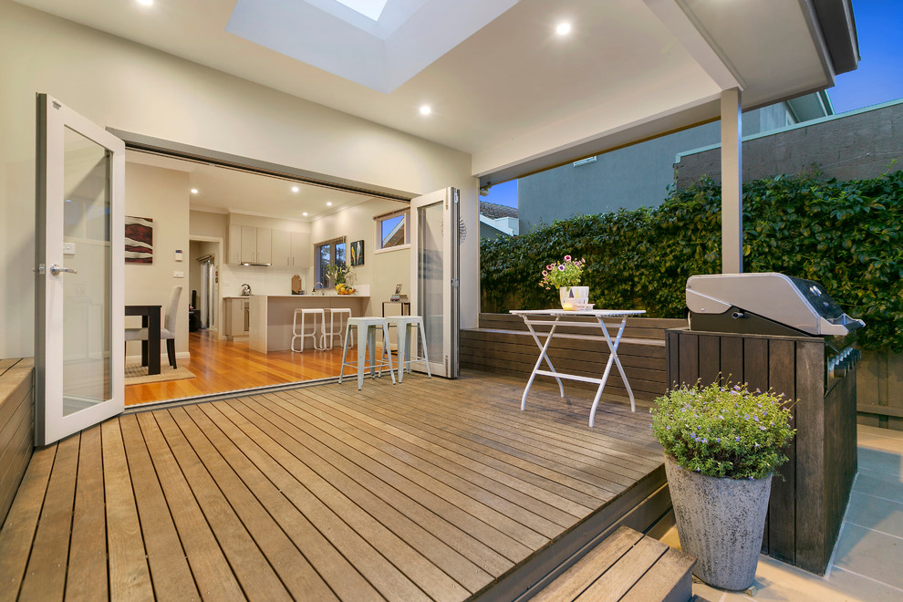 Ejemplo de terraza contemporánea en patio trasero y anexo de casas