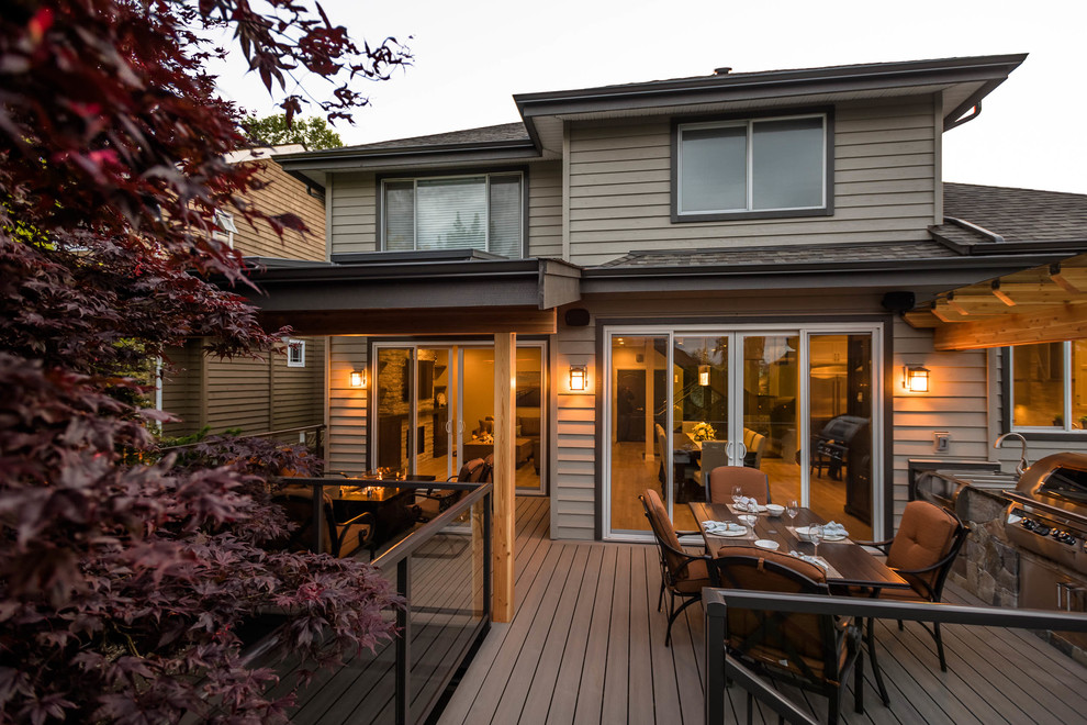 Imagen de terraza actual de tamaño medio en patio trasero con cocina exterior y toldo