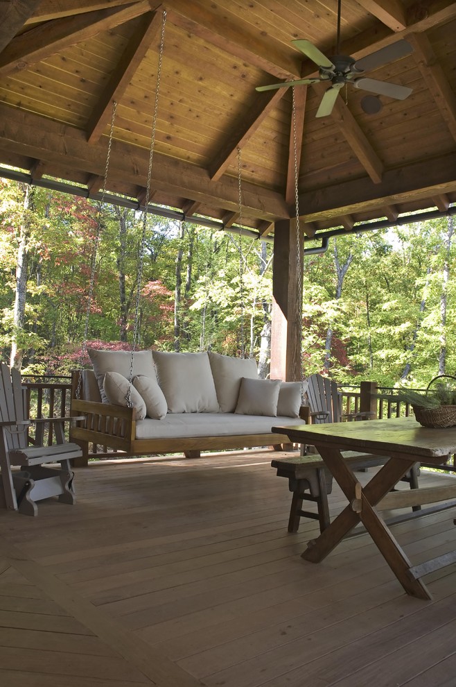 Large mountain style backyard deck photo in Other with a roof extension and a fire pit