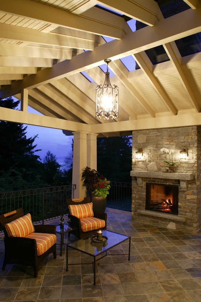 Large elegant backyard deck photo in Vancouver with a fire pit and a roof extension