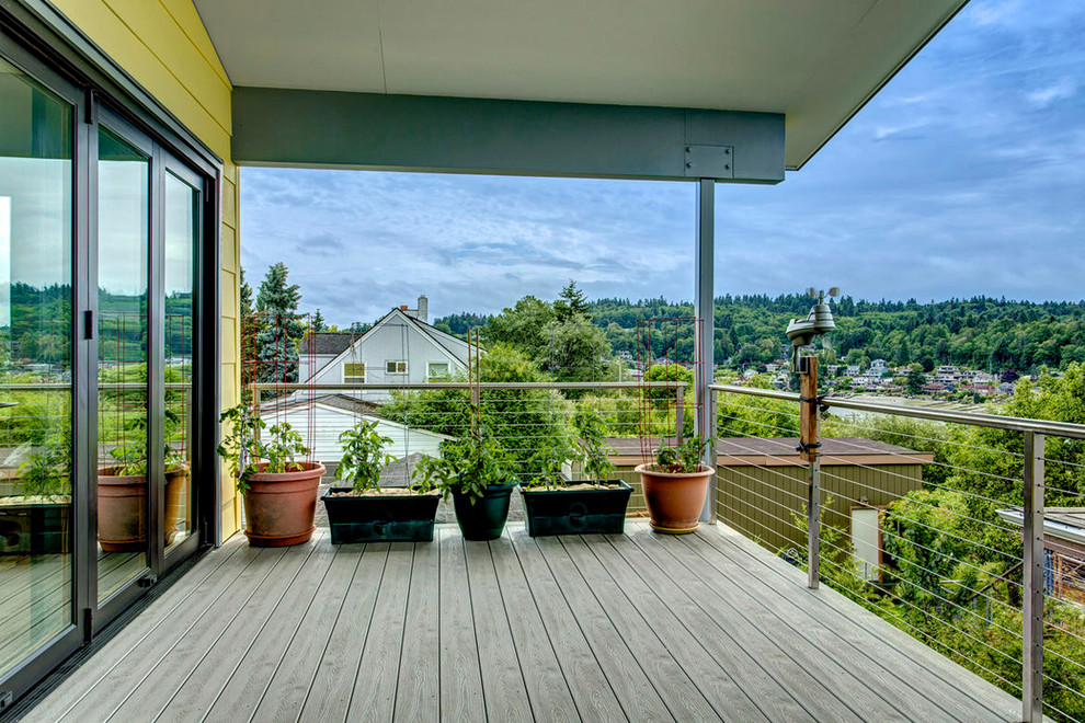 Bild på en stor funkis terrass på baksidan av huset, med takförlängning