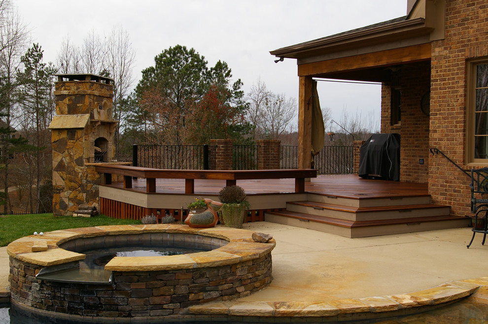 Large rustic back terrace in Charlotte with a fire feature and a roof extension.