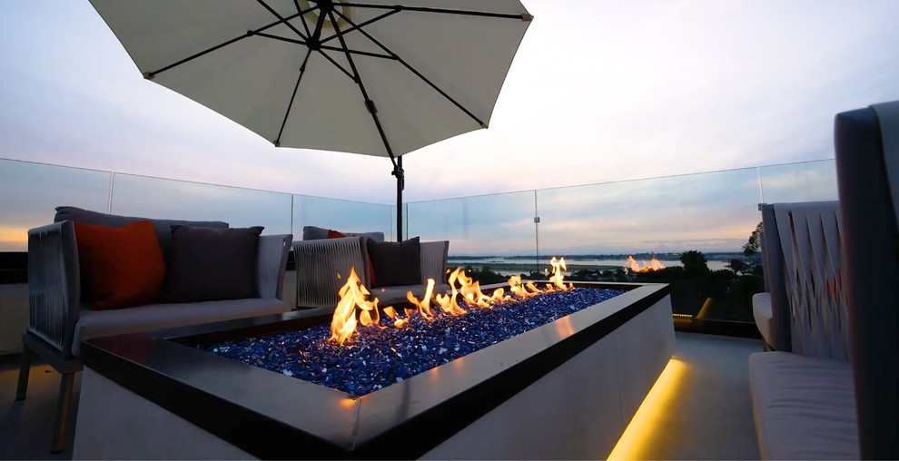 Design ideas for a large modern roof terrace in San Diego with a fire feature and an awning.