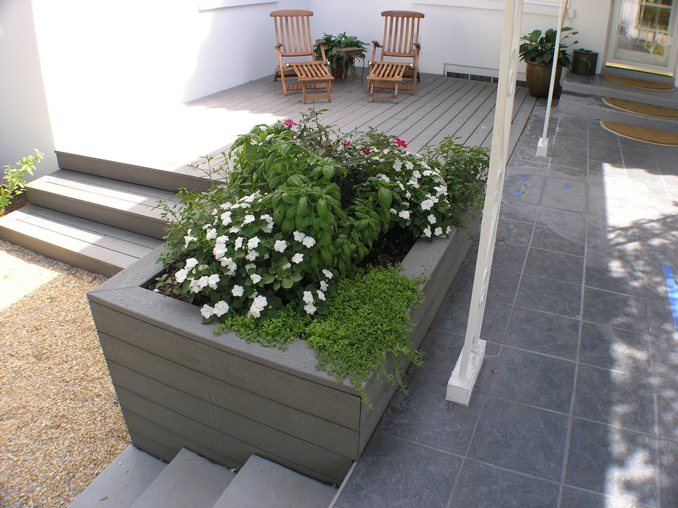 Ispirazione per una terrazza chic di medie dimensioni e dietro casa con un giardino in vaso e una pergola