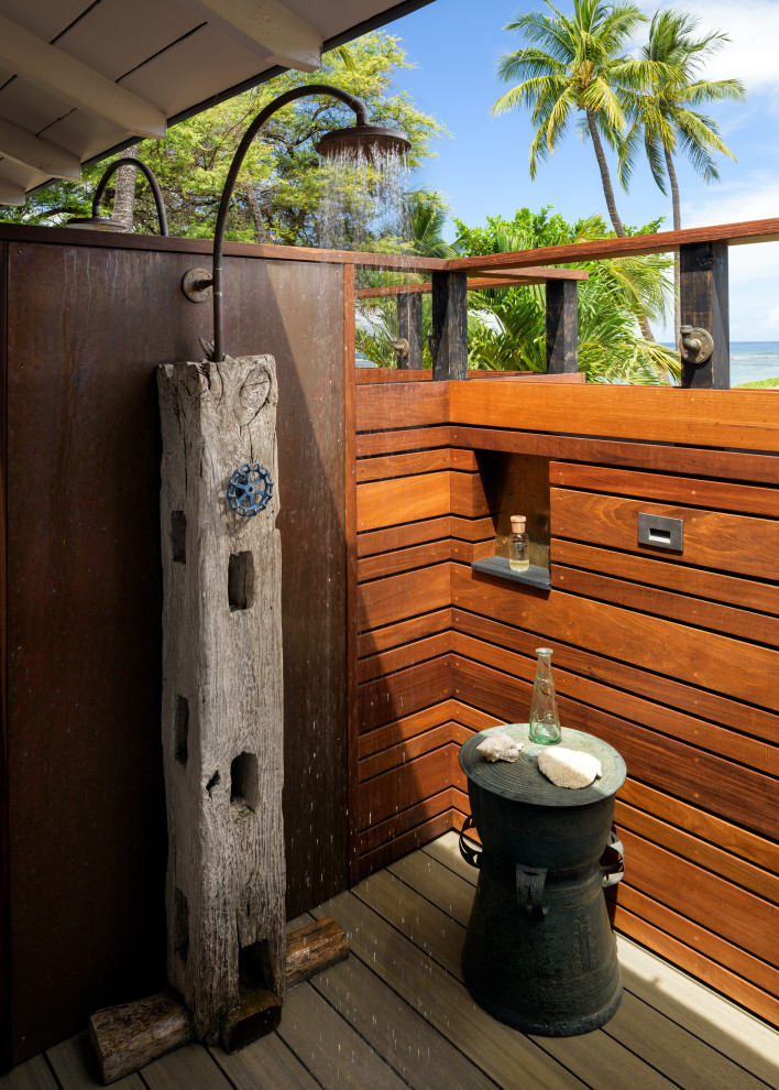 Photo of a small beach style back terrace in Hawaii with an outdoor shower and a roof extension.