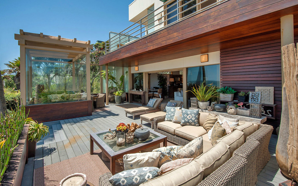 Example of a beach style deck design in Los Angeles with a pergola