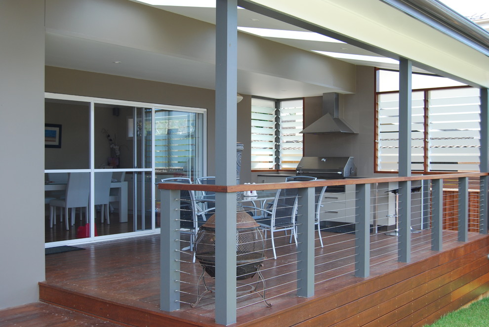 Cette image montre une terrasse arrière design de taille moyenne avec une cuisine d'été et une extension de toiture.