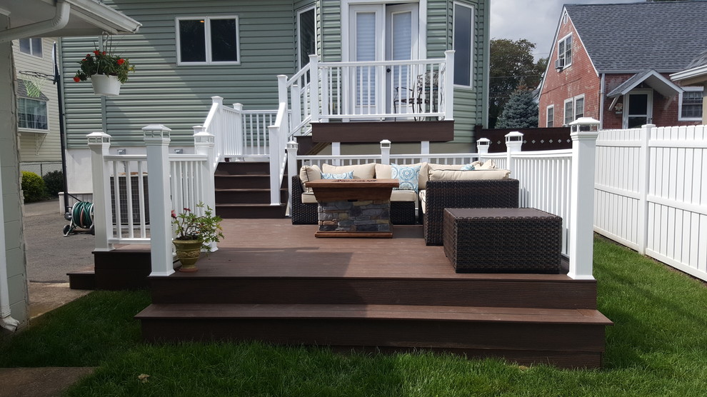 Example of a mid-sized classic backyard deck design in New York with a fire pit and no cover