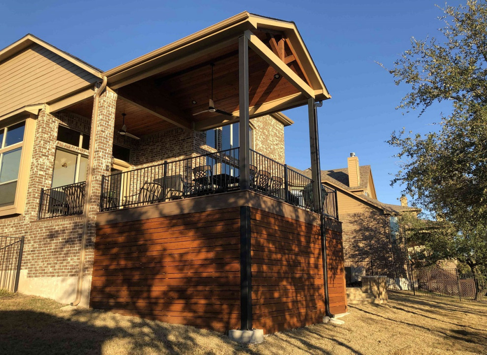 This is an example of an expansive eclectic back first floor metal railing terrace in Austin with a fire feature and a roof extension.