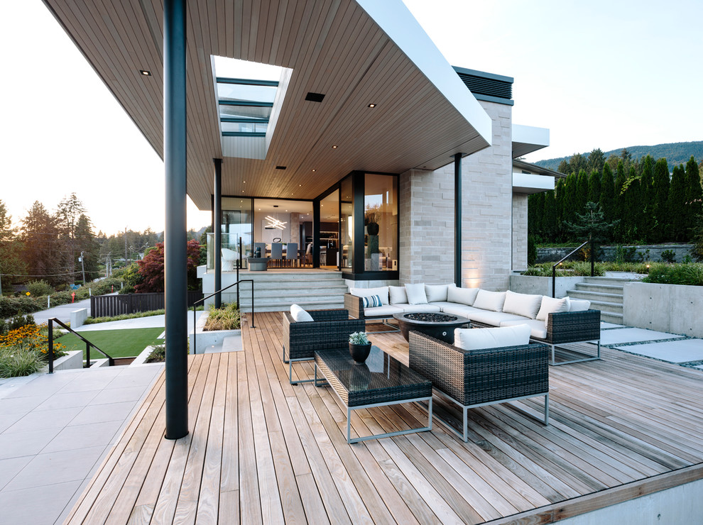 Idée de décoration pour une grande terrasse design avec une extension de toiture.