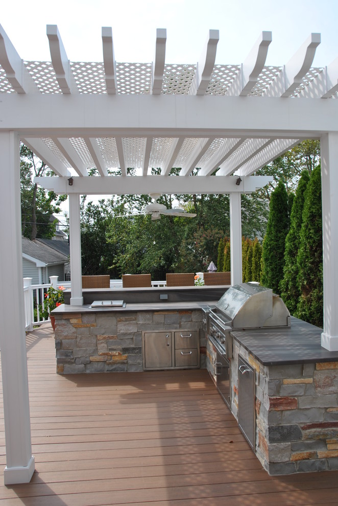 Modelo de terraza clásica pequeña en patio trasero con cocina exterior y pérgola