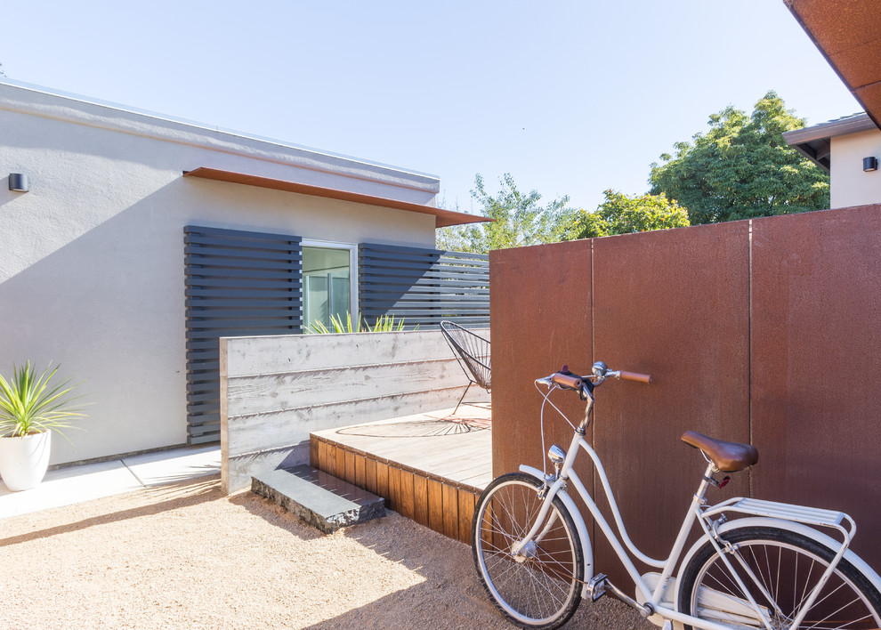 Ispirazione per una terrazza minimalista di medie dimensioni e dietro casa con un tetto a sbalzo