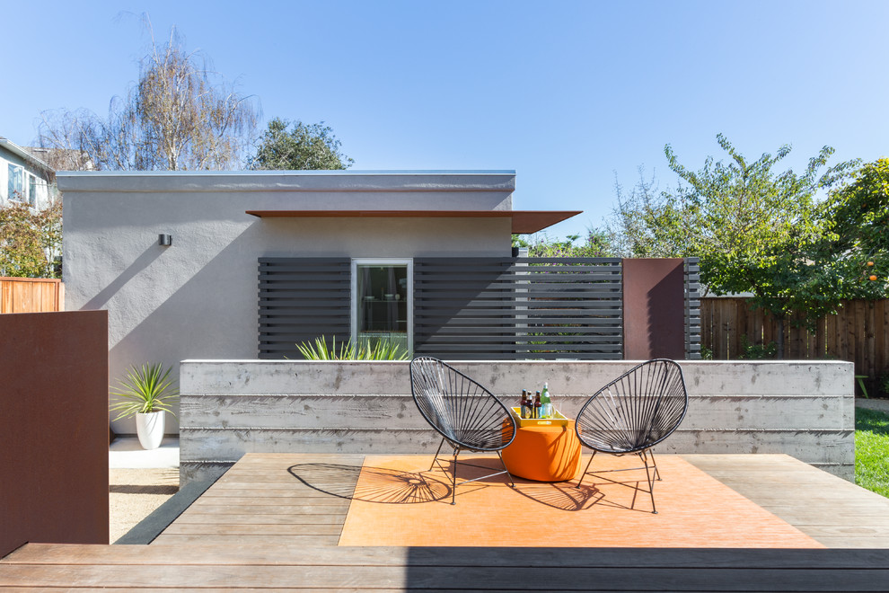 Modelo de terraza moderna de tamaño medio en patio trasero y anexo de casas