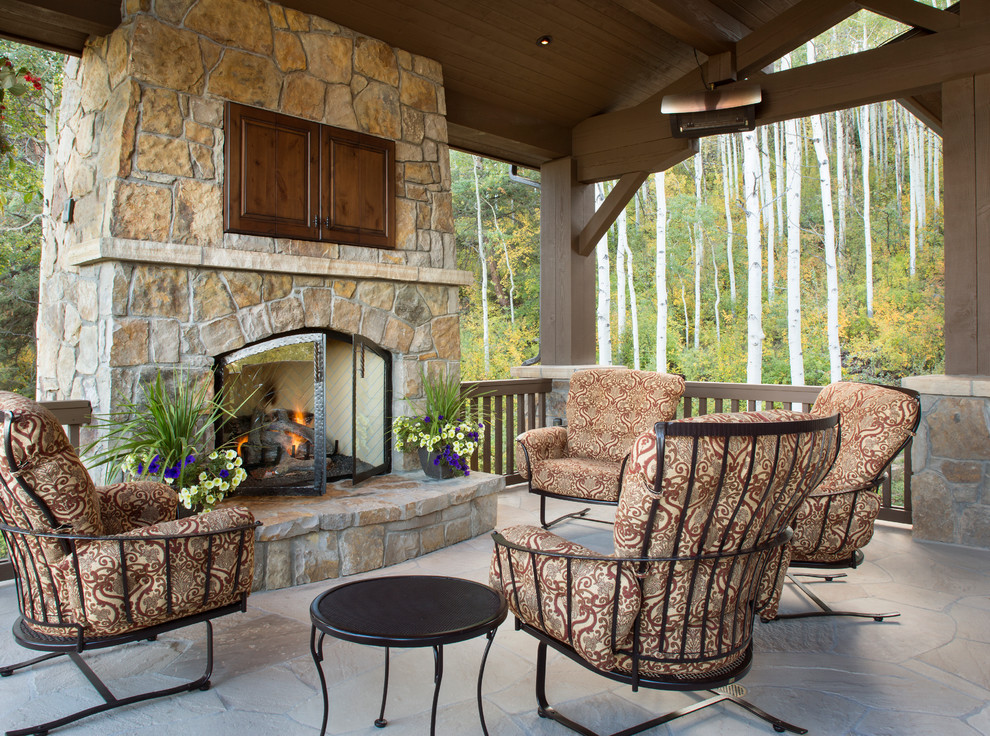 Example of a mid-sized mountain style side yard deck design in Denver with a fire pit and a roof extension