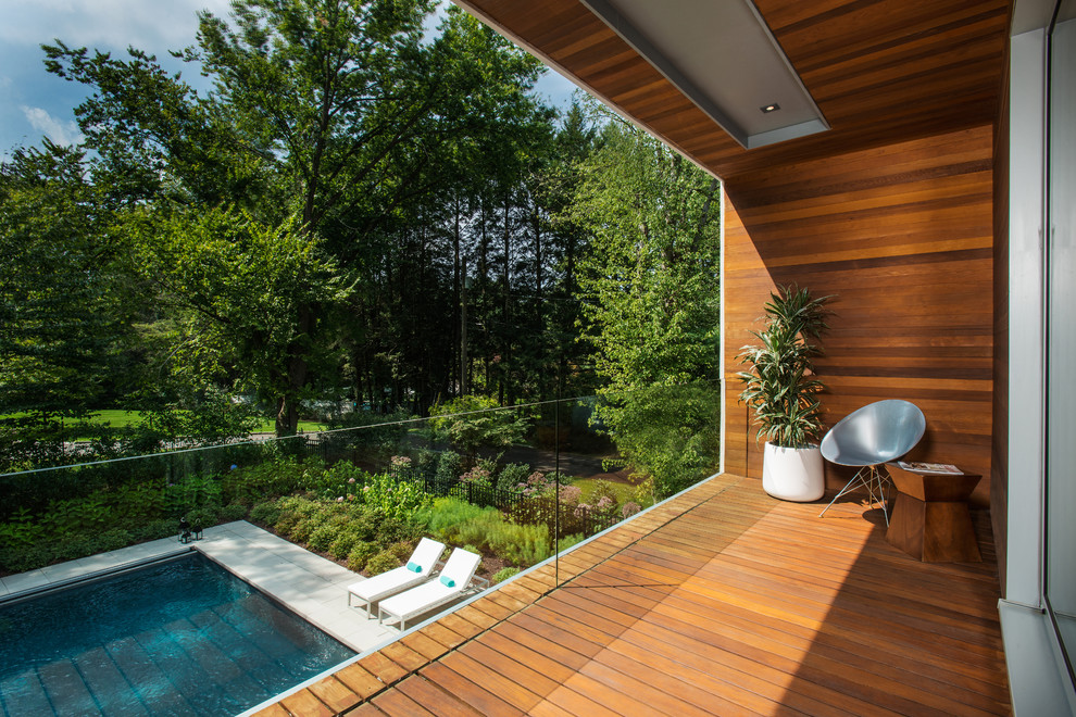 Esempio di una terrazza design con un giardino in vaso e un tetto a sbalzo