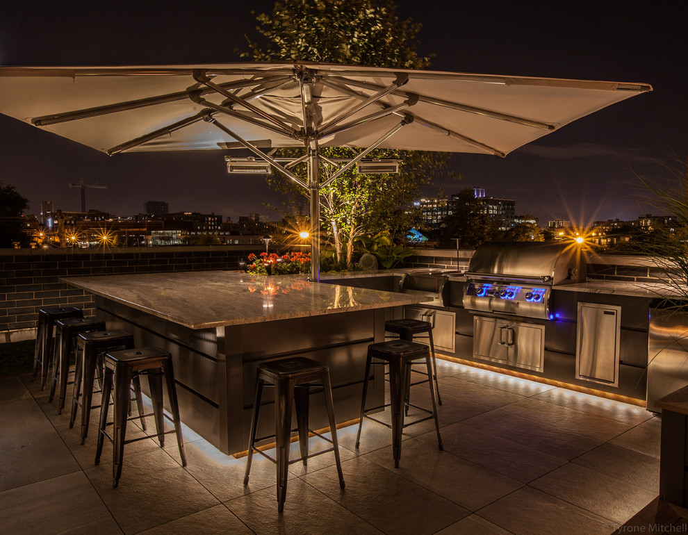 This is an example of a medium sized contemporary roof terrace in Chicago with an outdoor kitchen and an awning.