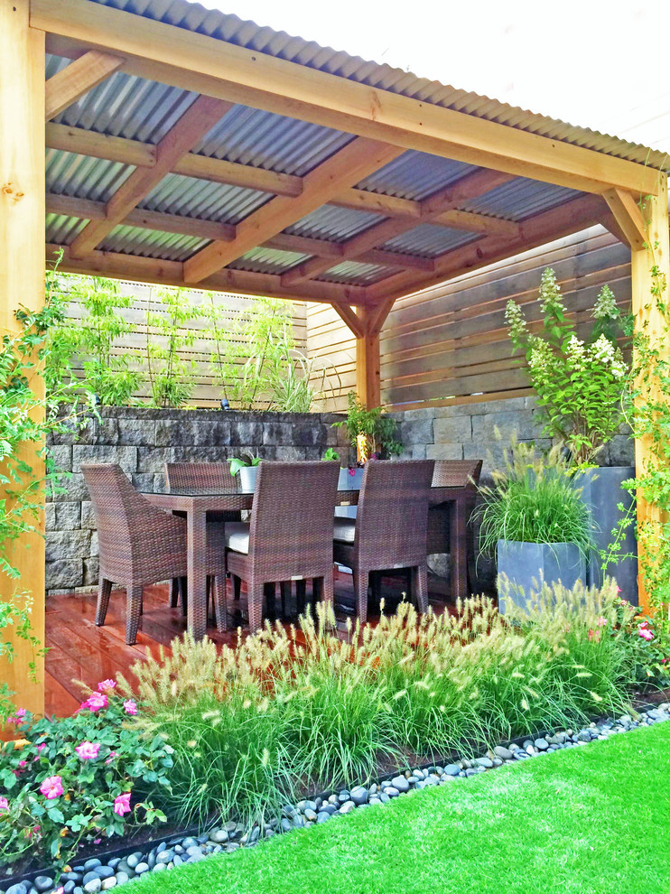 Foto på en funkis terrass på baksidan av huset, med en pergola