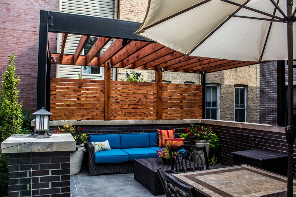 Ejemplo de terraza actual grande en patio trasero con cocina exterior y pérgola