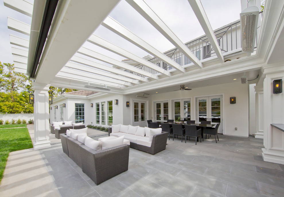 Idée de décoration pour une grande terrasse arrière minimaliste avec une cuisine d'été et une extension de toiture.