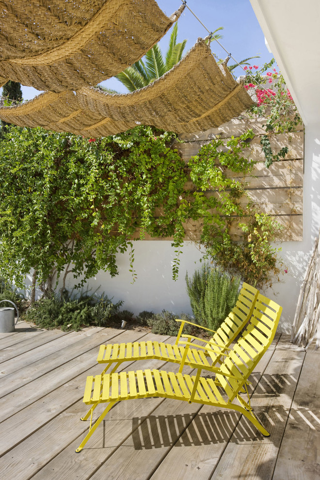 На фото: терраса среднего размера на боковом дворе в средиземноморском стиле с козырьком с