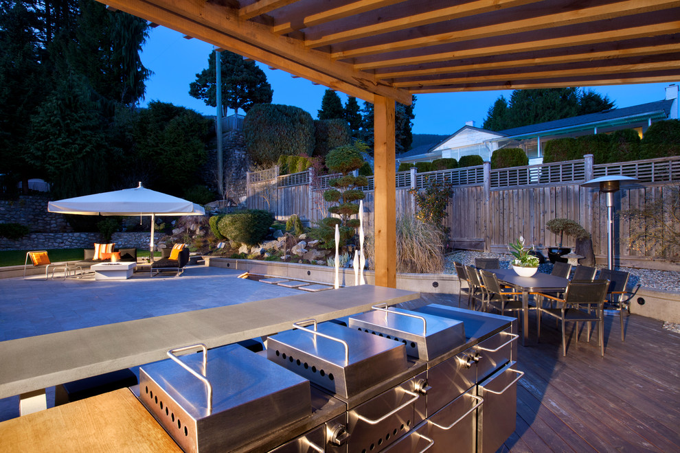 Exemple d'une terrasse arrière rétro de taille moyenne avec une cuisine d'été et une pergola.