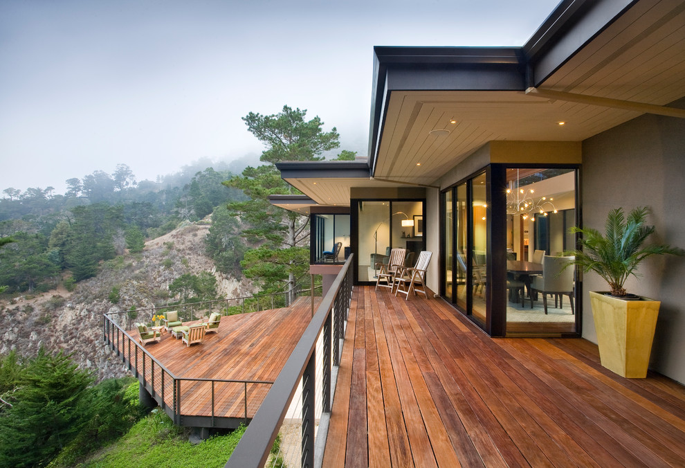Inspiration for a huge contemporary backyard deck remodel in Other with a roof extension