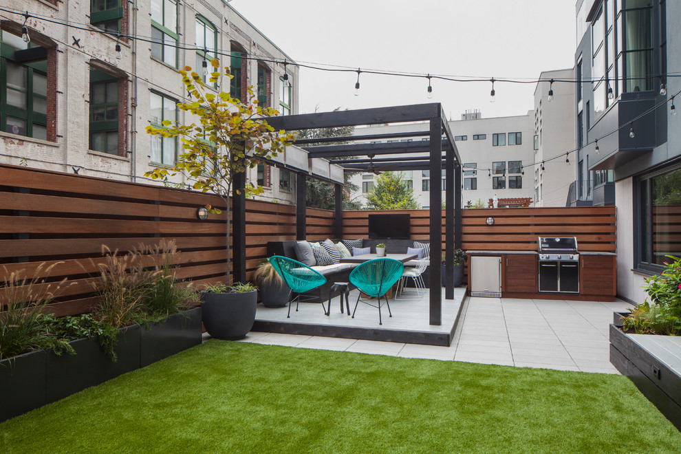 This is an example of a contemporary terrace in New York with an outdoor kitchen and a pergola.