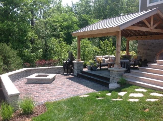 Rustic back terrace in Chicago with a fire feature and a pergola.