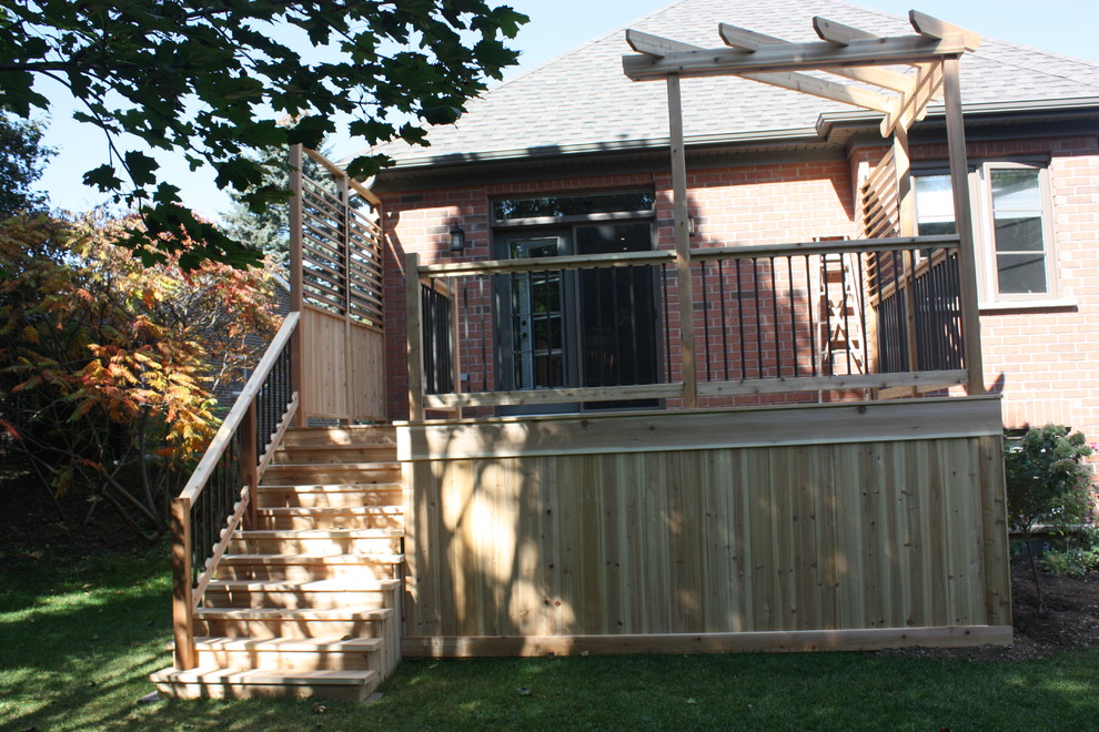 Réalisation d'une terrasse arrière design de taille moyenne avec une pergola.