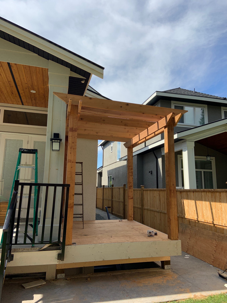 Design ideas for a small rustic back terrace in Vancouver with a pergola.