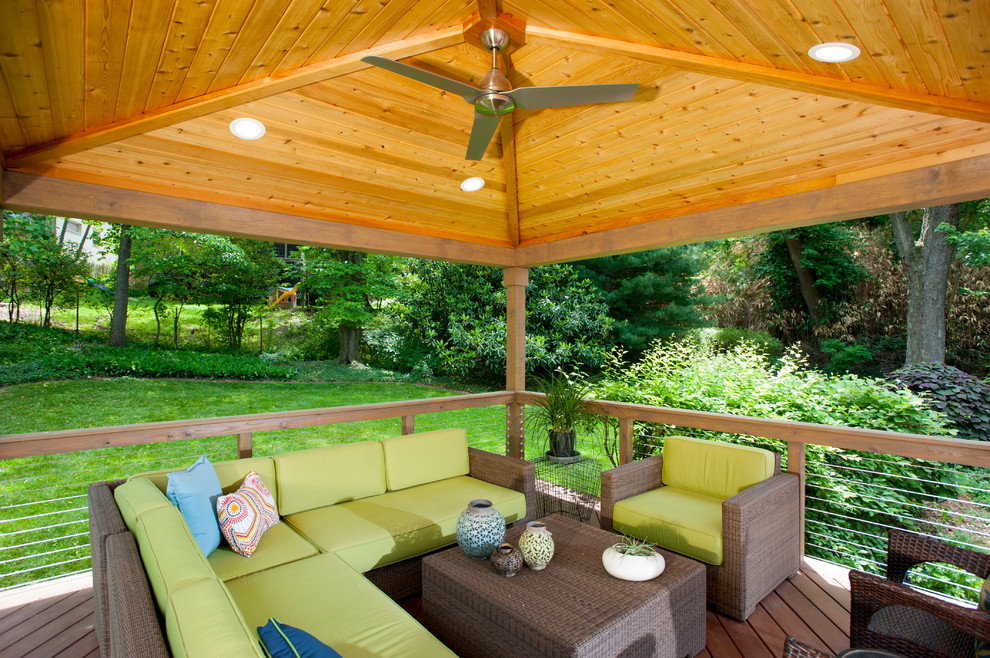 Example of a mid-sized trendy backyard deck design in DC Metro with a pergola
