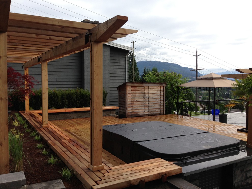 This is an example of a medium sized traditional back terrace in Vancouver with a pergola.