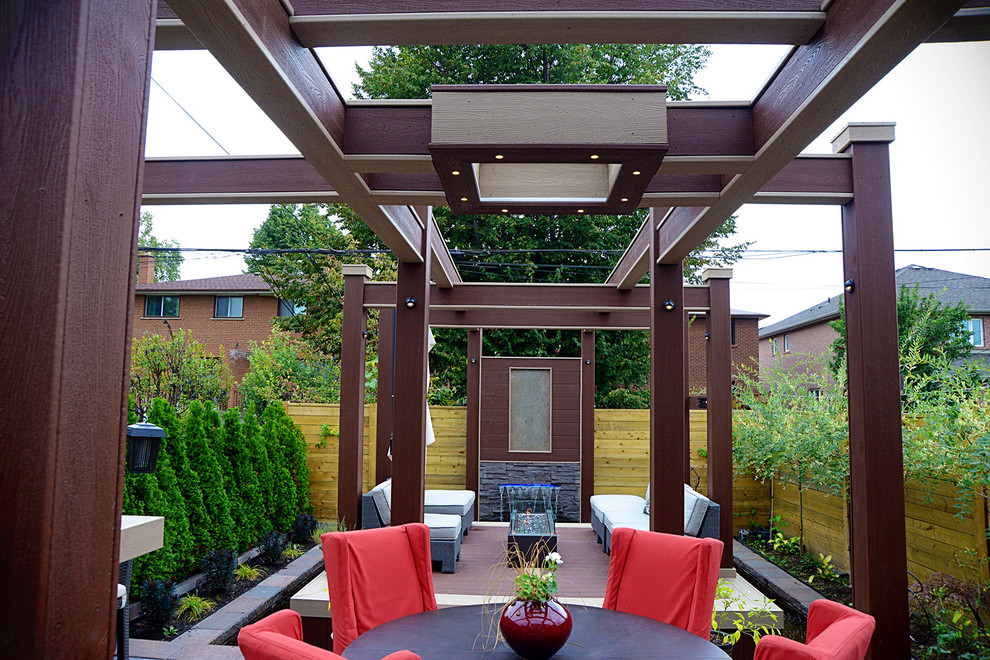 This is an example of a medium sized contemporary back terrace in Toronto with a water feature and a pergola.
