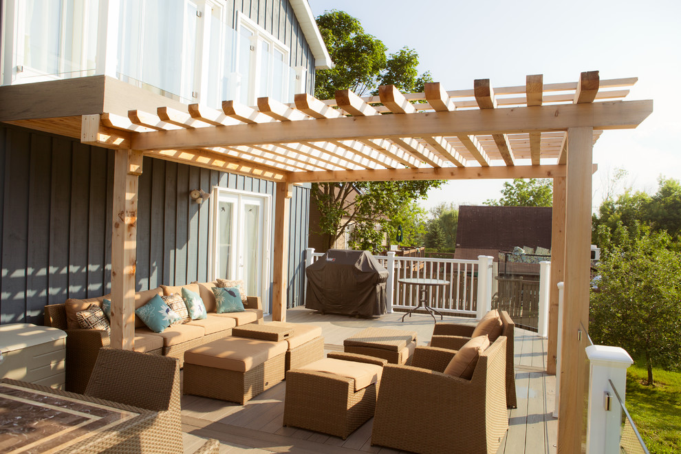 Deck - large modern backyard deck idea in Toronto with a pergola